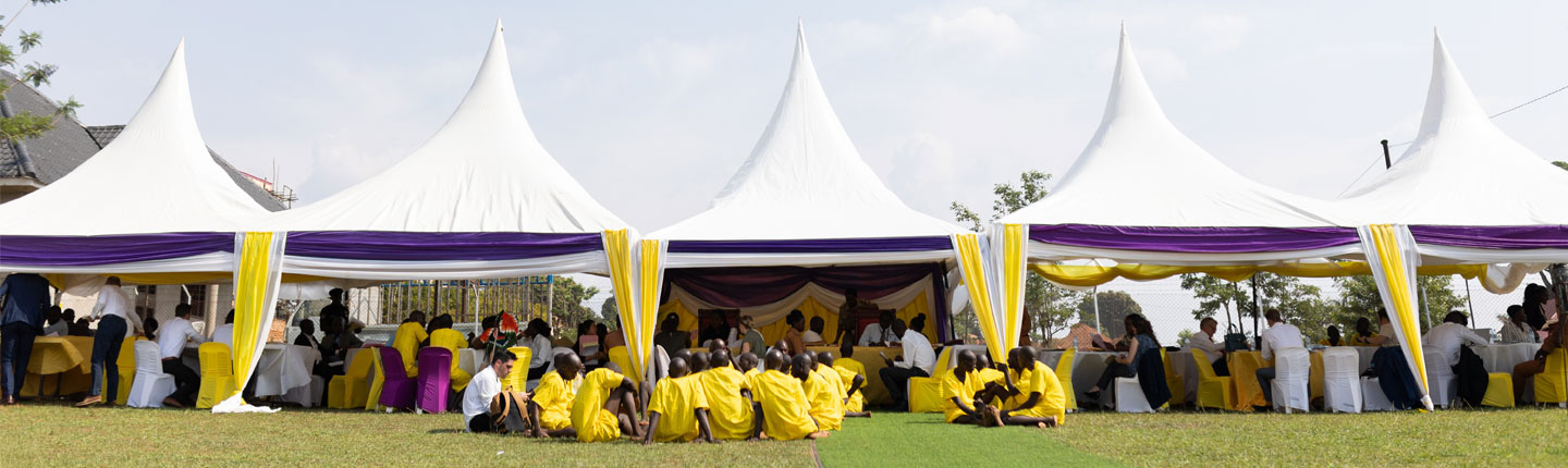 People outside on lawn under tents